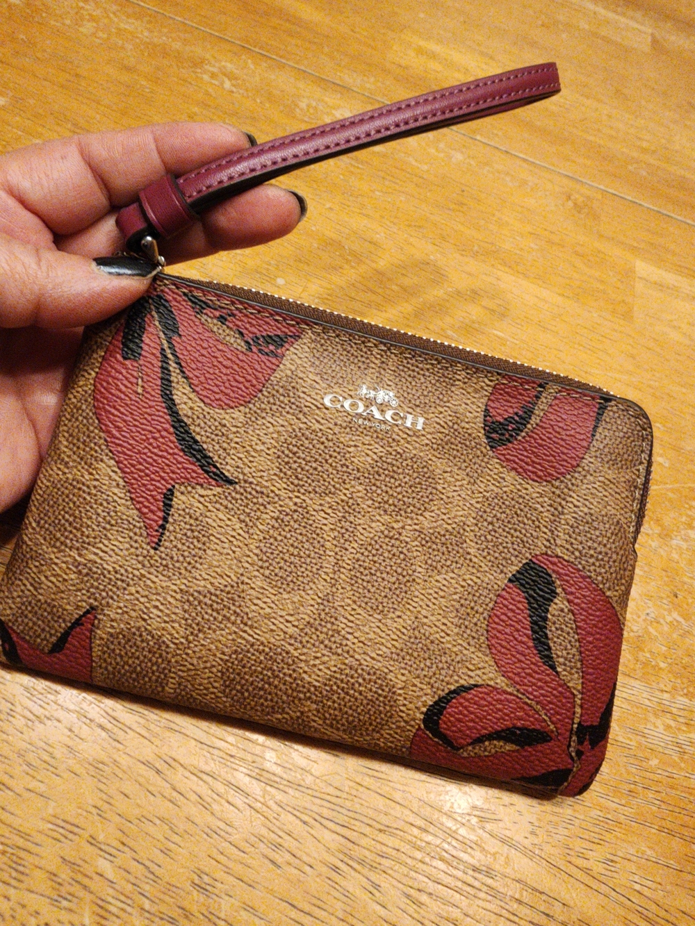 Coach Corner Zip Wristlet featuring a distinctive red bow print